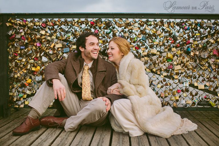 A couple locking their padlocks onto the Pont Des Arts bridge in Paris in a romantic tradition to celebrate their love.