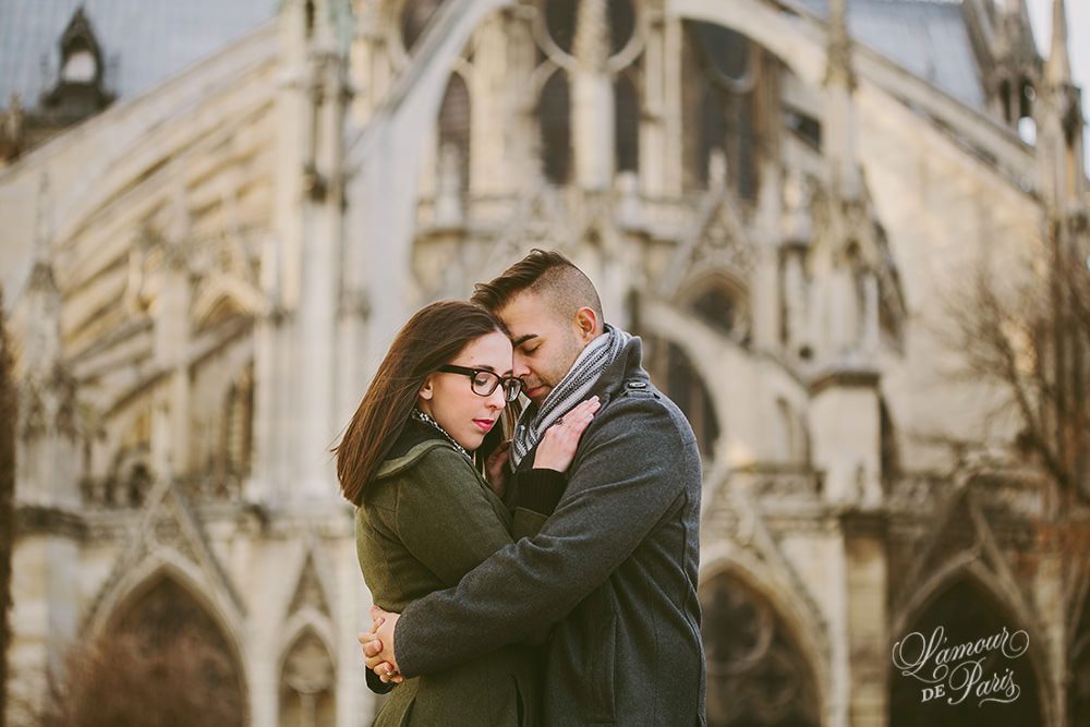 Romantic portraits of Sara and Rocky Garza in front of Notre Dame cathedral by Paris portrait photographer Stacy Reeves for L'Amour de Paris photography studio
