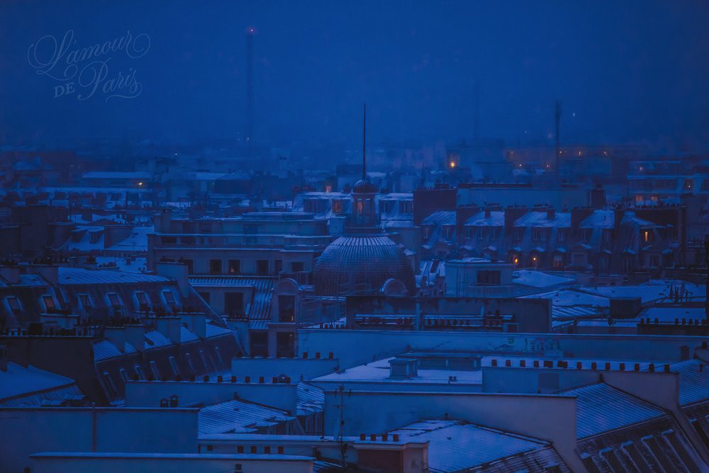 Snow covered rooftops of Paris photographed from the Galeries Lafayette terrace at night photographed by Stacy Reeves by Paris travel planning and photography blog L'Amour de Paris