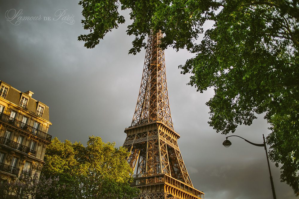 Sun shining on the Eiffel Tower during a Paris thunderstorm