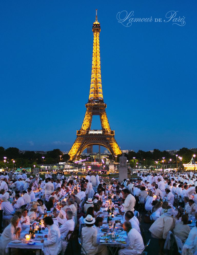 Diner en Blanc, also known as Diner in White, a top secret invitiation-only flash mob in Paris, France where 11,000 people dressed entirely in white clothes spontaneously set up tables and chairs in front of historic landmarks one night a year. The 2013 Diner en blanc, held on July 13, took place in the Louvre courtyard and by the Trocadero fountains in front of the Eiffel Tower. Photographed by Paris wedding and portrait photographer Stacy Reeves for vacation planning blog L'Amour de Paris.