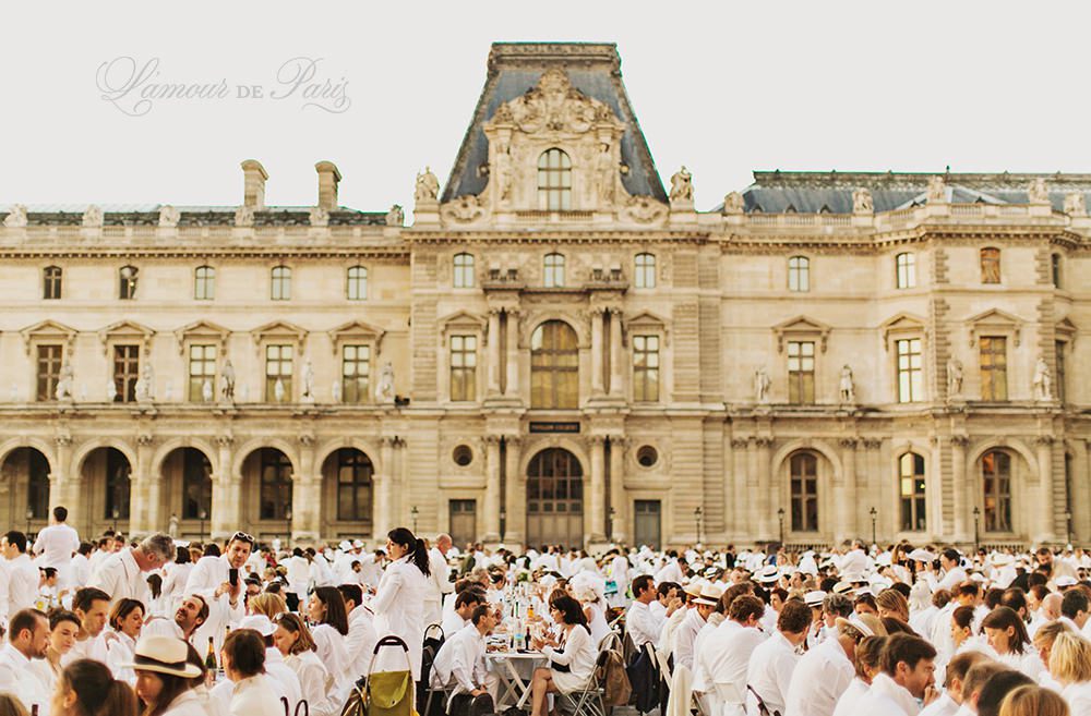 Diner en Blanc, also known as Diner in White, a top secret invitiation-only flash mob in Paris, France where 11,000 people dressed entirely in white clothes spontaneously set up tables and chairs in front of historic landmarks one night a year. The 2013 Diner en blanc, held on July 13, took place in the Louvre courtyard and by the Trocadero fountains in front of the Eiffel Tower. Photographed by Paris wedding and portrait photographer Stacy Reeves for vacation planning blog L'Amour de Paris.