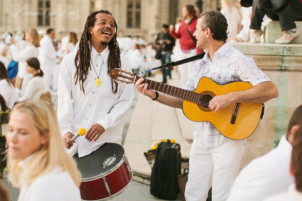 Diner en Blanc, also known as Diner in White, a top secret invitiation-only flash mob in Paris, France where 11,000 people dressed entirely in white clothes spontaneously set up tables and chairs in front of historic landmarks one night a year. The 2013 Diner en blanc, held on July 13, took place in the Louvre courtyard and by the Trocadero fountains in front of the Eiffel Tower. Photographed by Paris wedding and portrait photographer Stacy Reeves for vacation planning blog L'Amour de Paris.