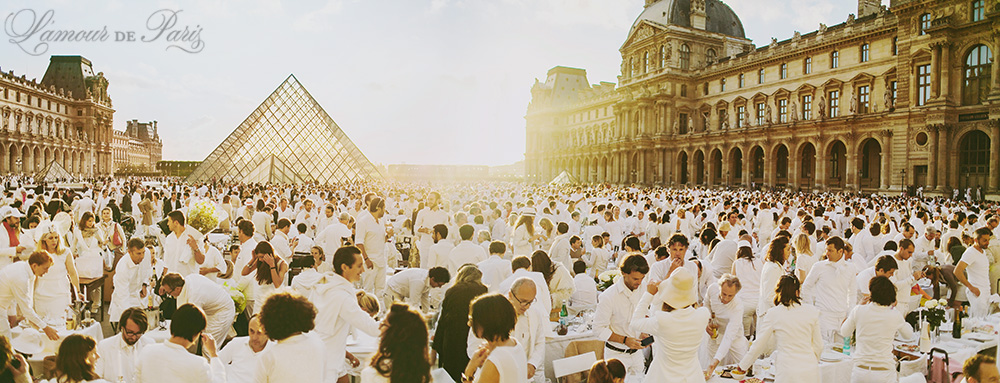 Diner en Blanc, also known as Diner in White, a top secret invitiation-only flash mob in Paris, France where 11,000 people dressed entirely in white clothes spontaneously set up tables and chairs in front of historic landmarks one night a year. The 2013 Diner en blanc, held on July 13, took place in the Louvre courtyard and by the Trocadero fountains in front of the Eiffel Tower. Photographed by Paris wedding and portrait photographer Stacy Reeves for vacation planning blog L'Amour de Paris.
