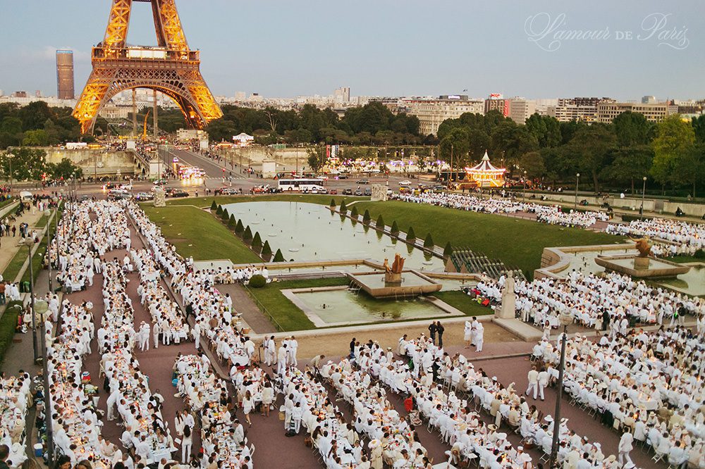 Diner en Blanc, also known as Diner in White, a top secret invitiation-only flash mob in Paris, France where 11,000 people dressed entirely in white clothes spontaneously set up tables and chairs in front of historic landmarks one night a year. The 2013 Diner en blanc, held on July 13, took place in the Louvre courtyard and by the Trocadero fountains in front of the Eiffel Tower. Photographed by Paris wedding and portrait photographer Stacy Reeves for vacation planning blog L'Amour de Paris.