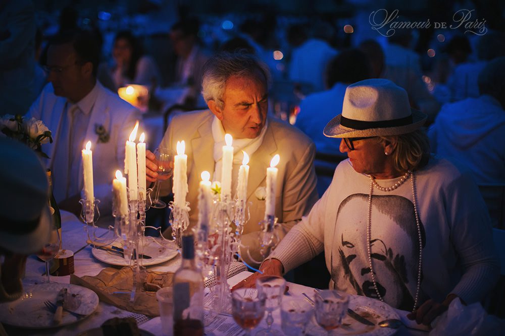 Diner en Blanc, also known as Diner in White, a top secret invitiation-only flash mob in Paris, France where 11,000 people dressed entirely in white clothes spontaneously set up tables and chairs in front of historic landmarks one night a year. The 2013 Diner en blanc, held on July 13, took place in the Louvre courtyard and by the Trocadero fountains in front of the Eiffel Tower. Photographed by Paris wedding and portrait photographer Stacy Reeves for vacation planning blog L'Amour de Paris.