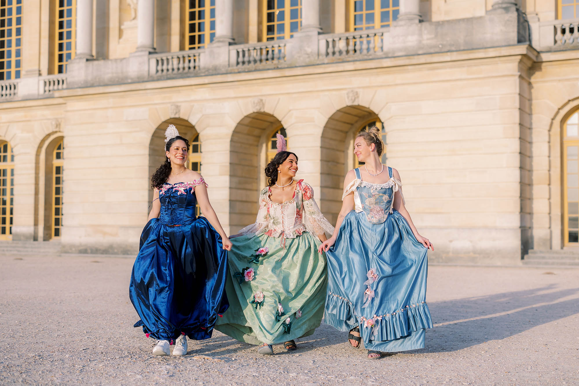 a group portrait of three girls in costume at the 2025 versailles masquerade ball