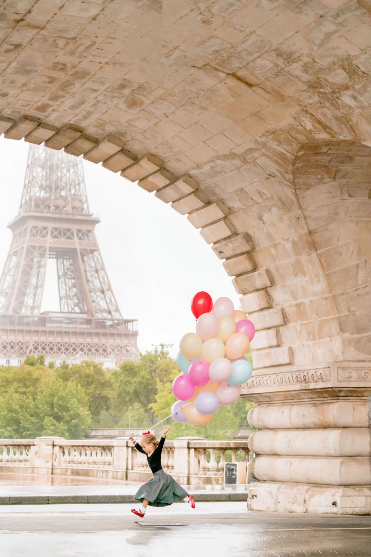 Paris family photo session at eiffel tower little girl with a bundle of colorful balloons