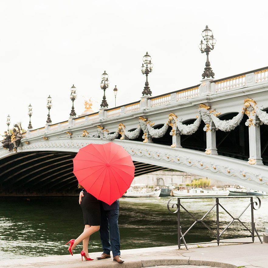 red heart shape umbrella with couple at pont alexandre