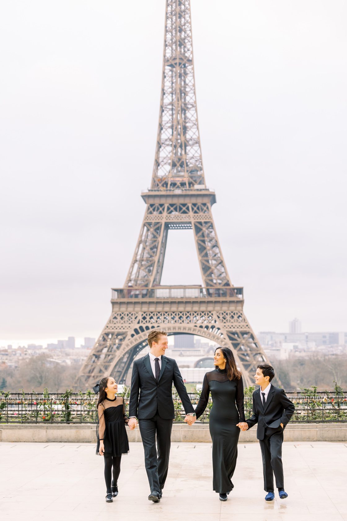 portrait of a stylish family wearing all black in paris in front of the eiffel tower