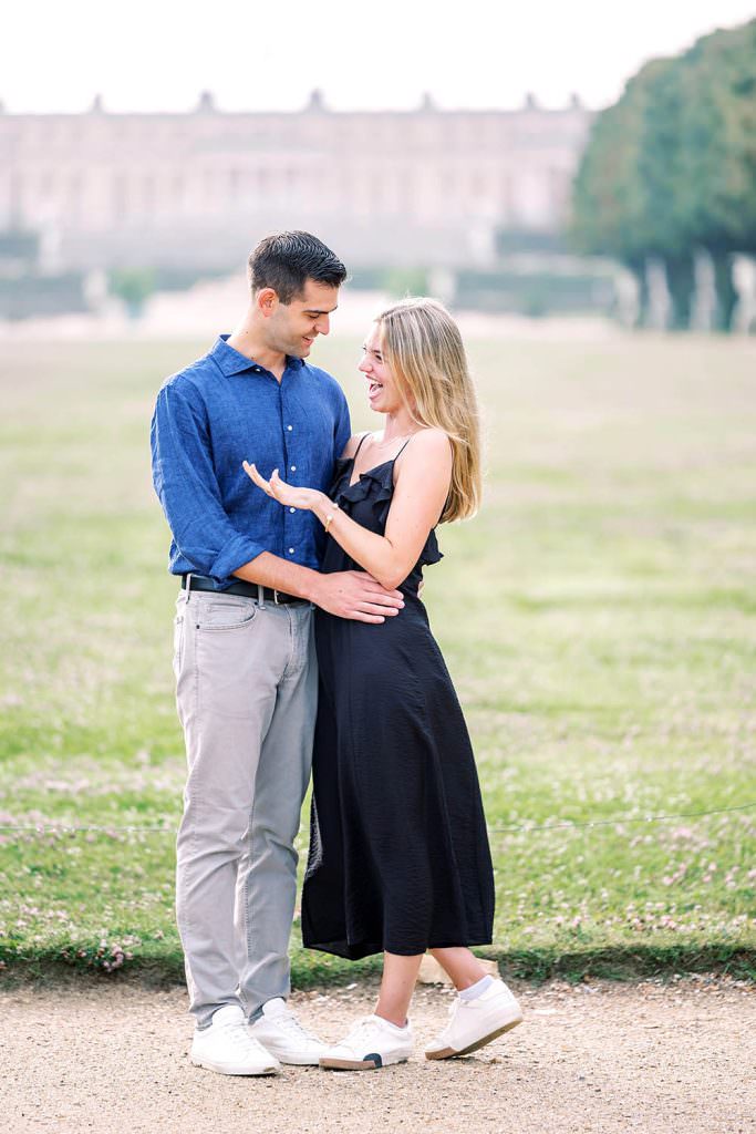 Bride-to-be looking surprised as fiancé proposes at Versailles