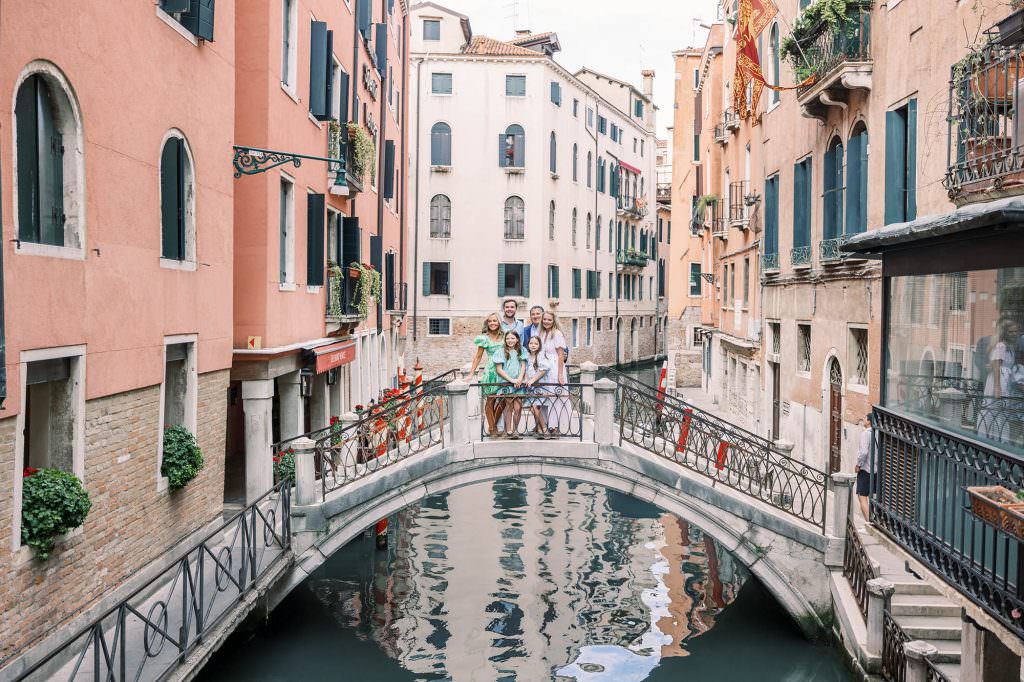 Happy family posing on a Venetian bridge