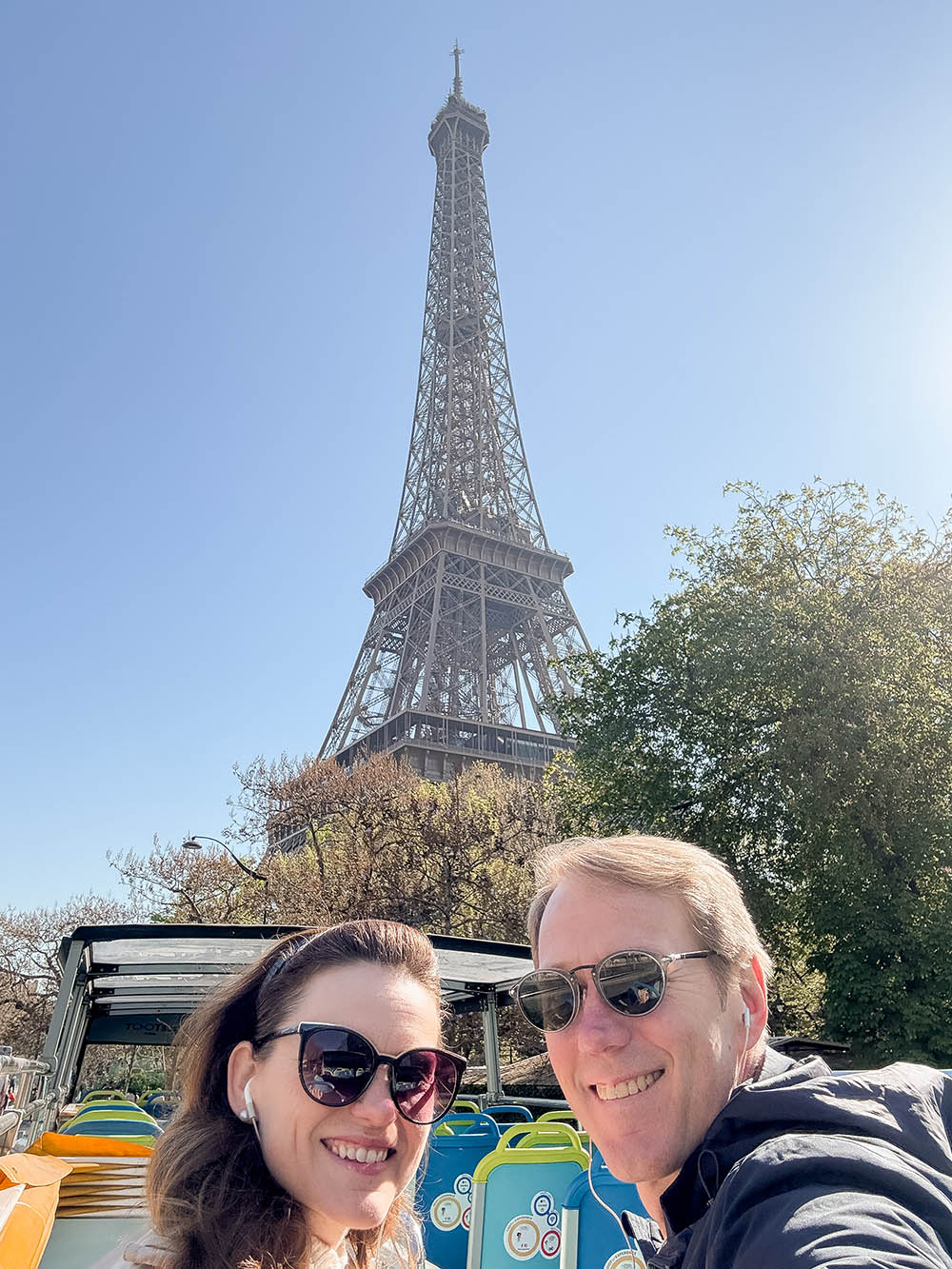 couple at the eiffel tower seen from paris hop on hop off bus tour