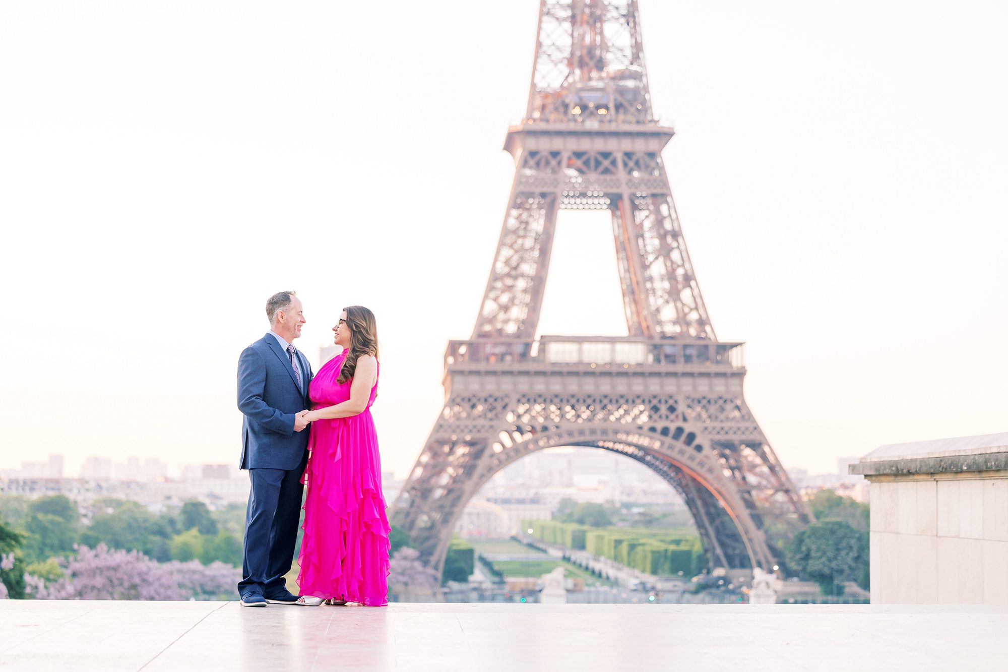 couple holding hands at the eiffel tower