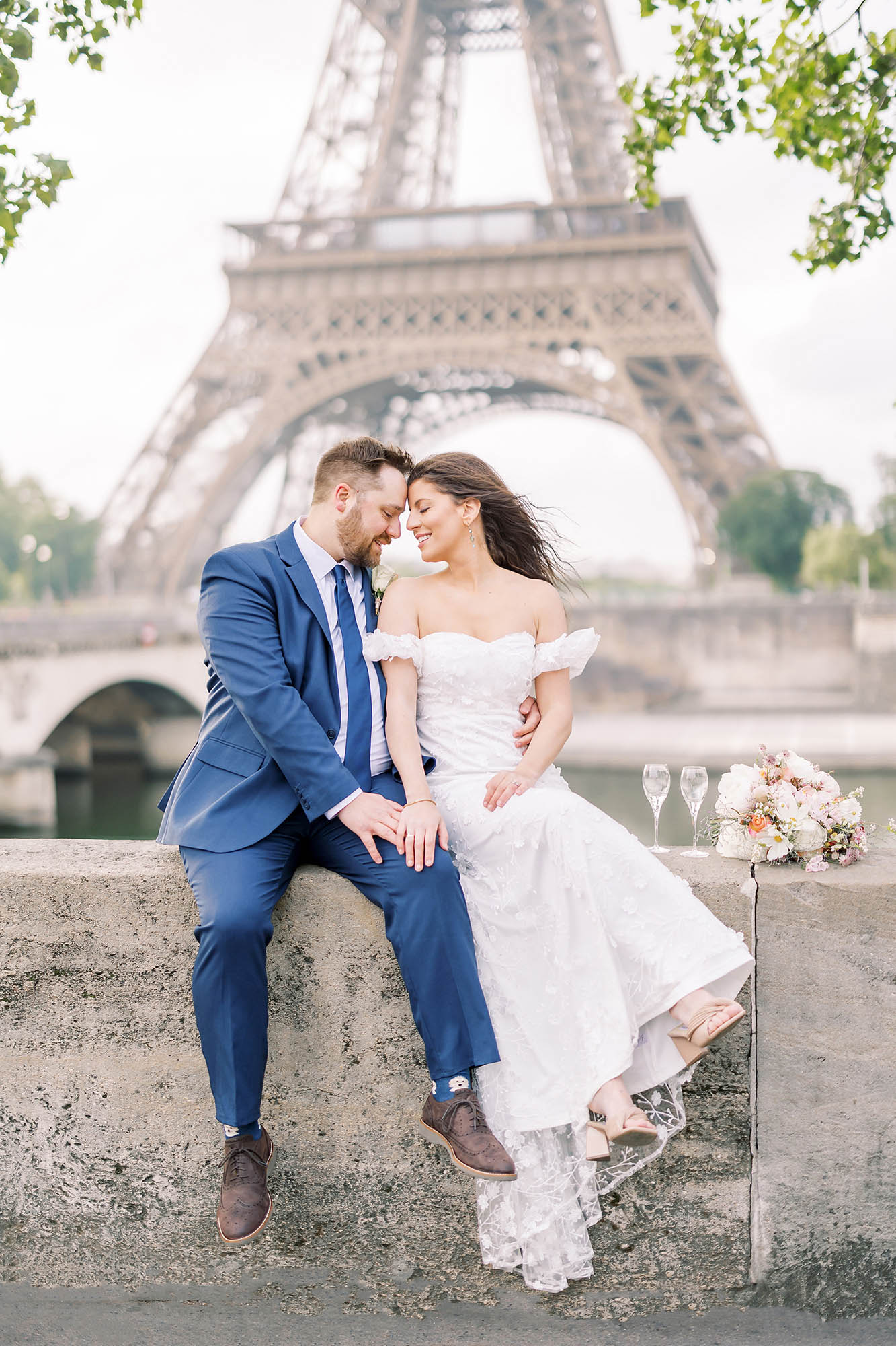 bride and groom taking a portrait with champagne in front of the eiffel tower after eloping in Paris, paris photographer