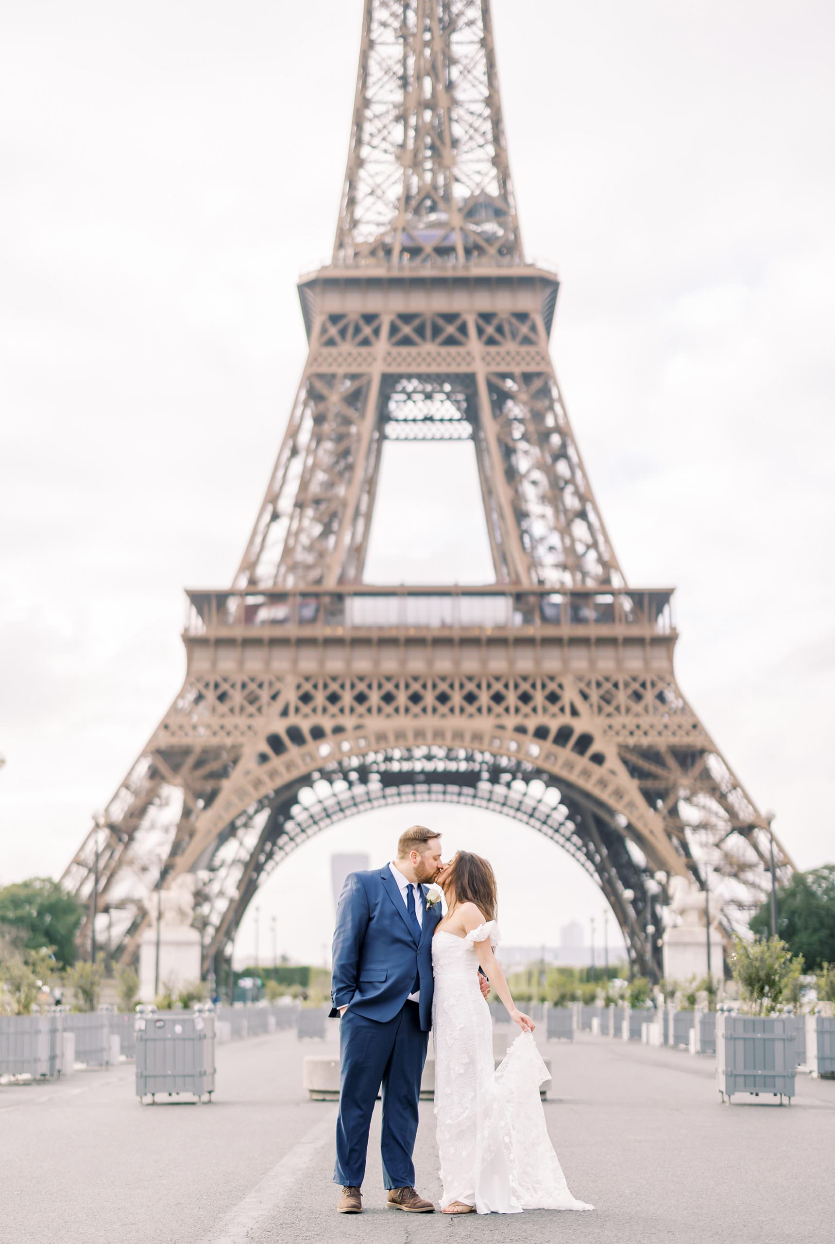 bride and groom's portrait kissing in the middle of the road in front of the eiffel tower