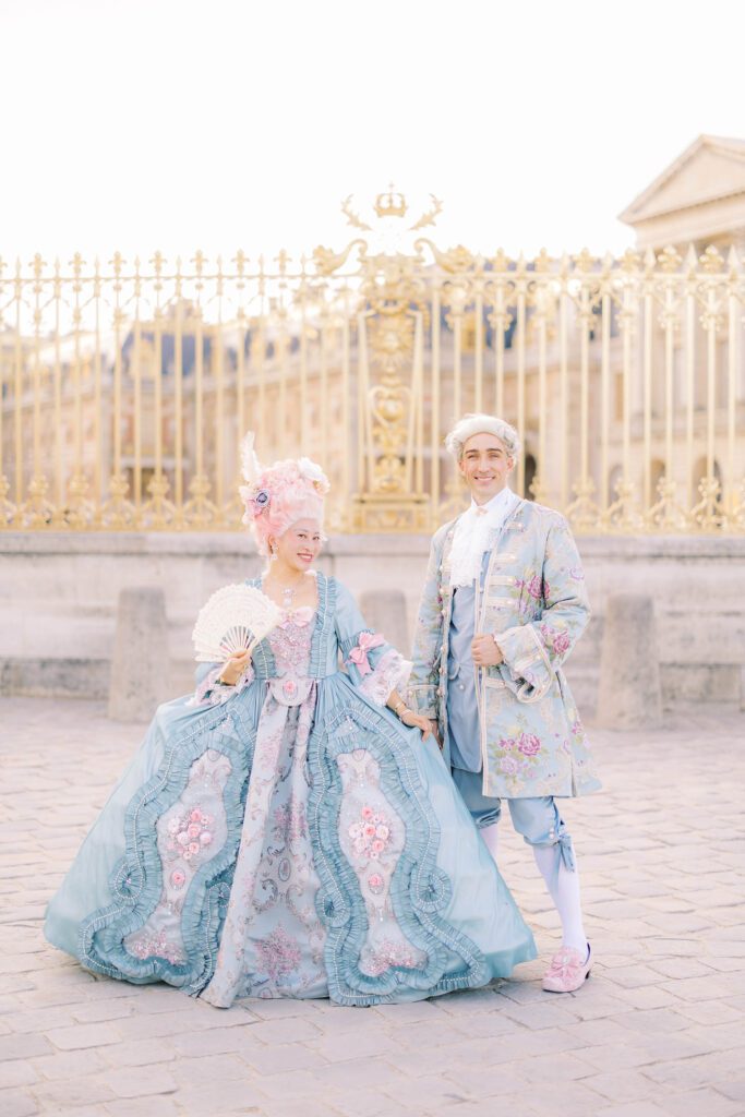 grand masked ball of versailles attendees in costume outside the golden gates