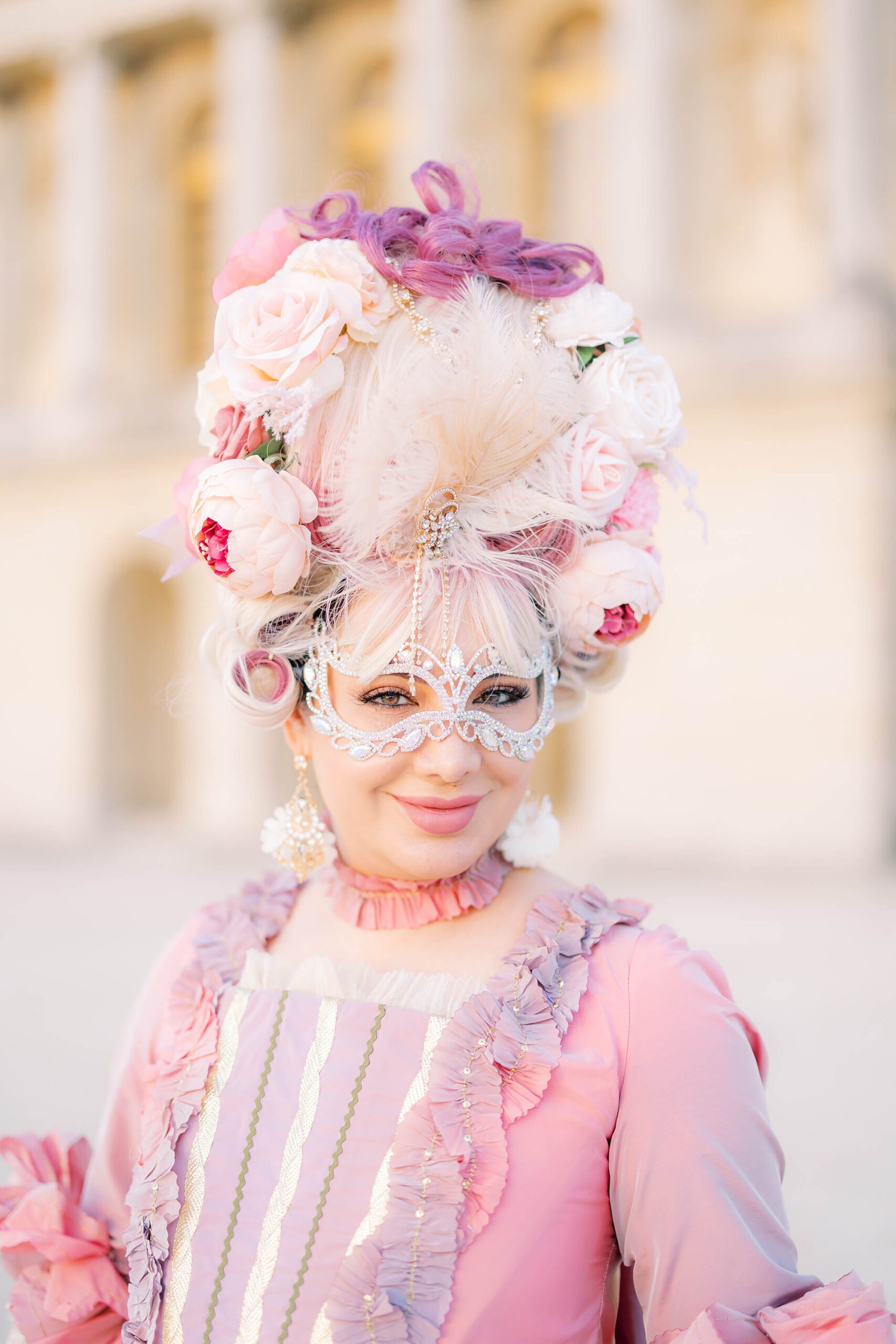 Close-up detail of a Venetian mask, gown, and wig at the Versailles Masked Ball
