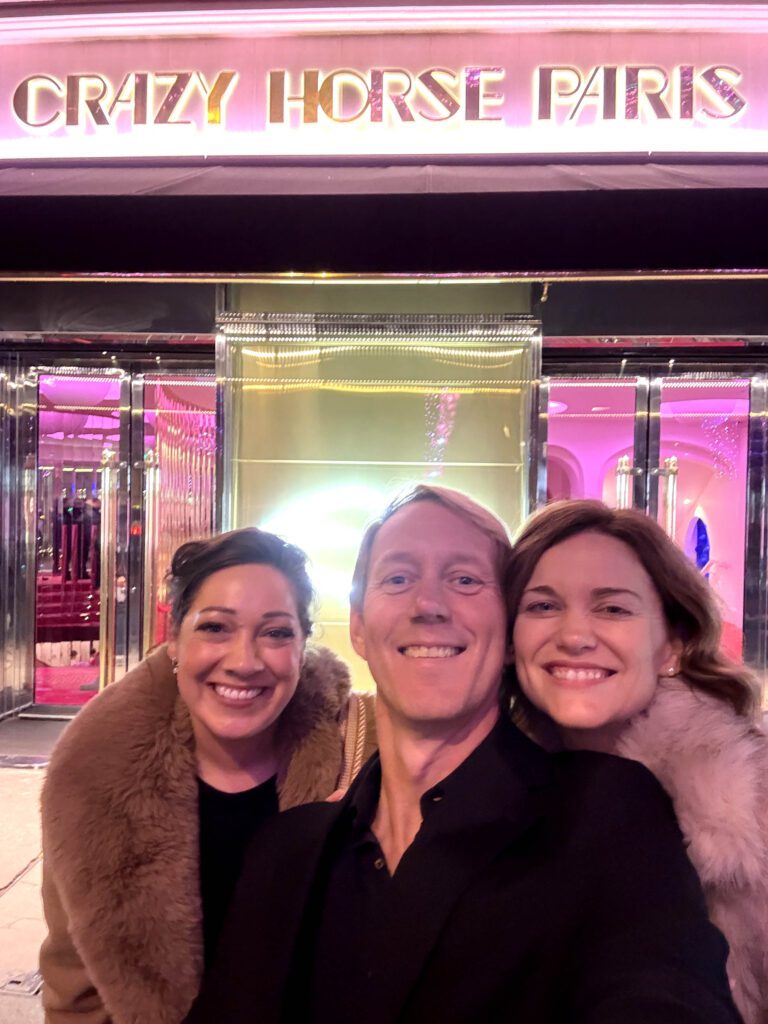 tourists taking a selfie in front of the crazy horse cabaret theater in Paris