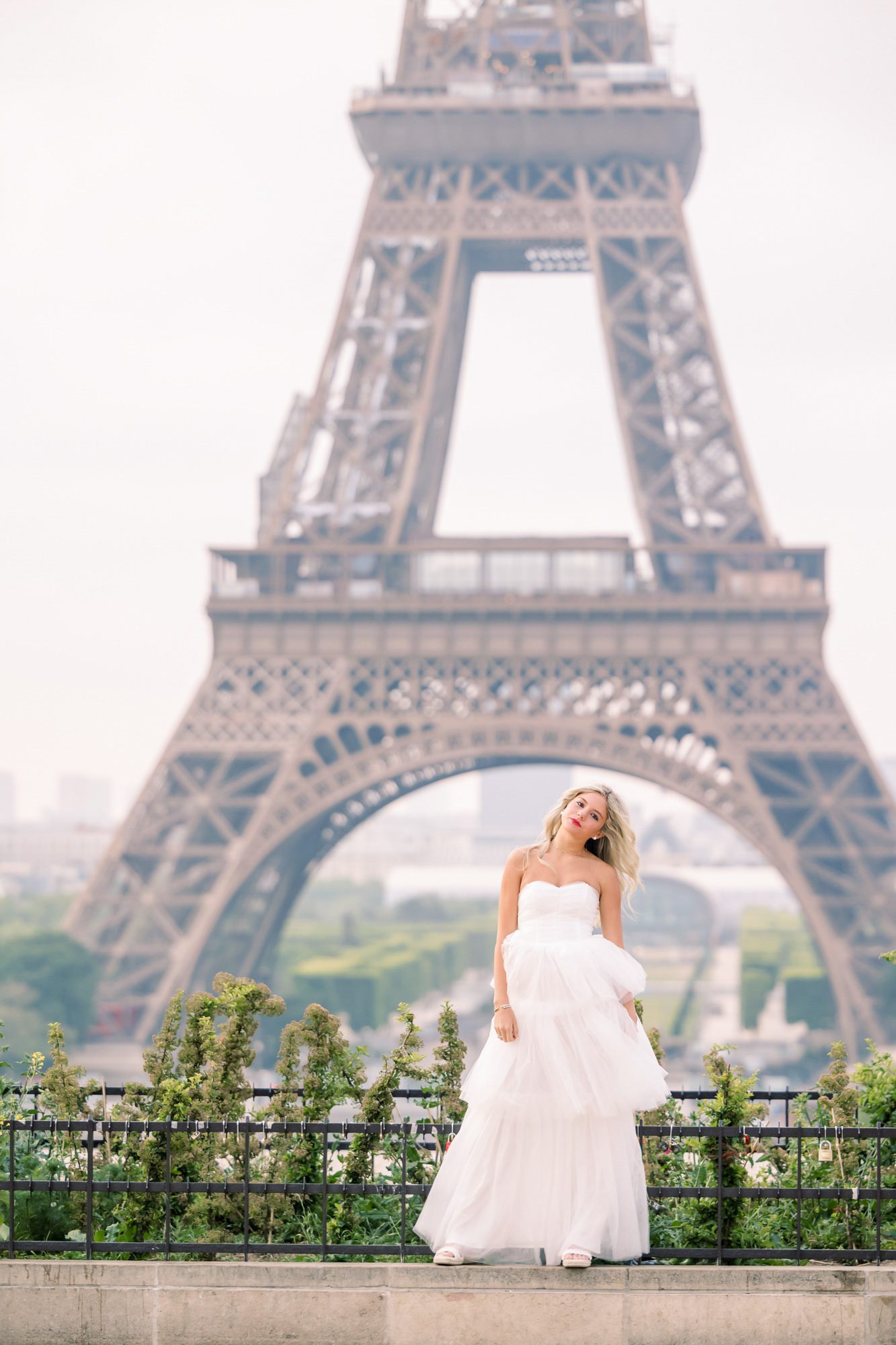 Dreamy Paris senior session featuring a girl in a white dress in front of the Eiffel Tower