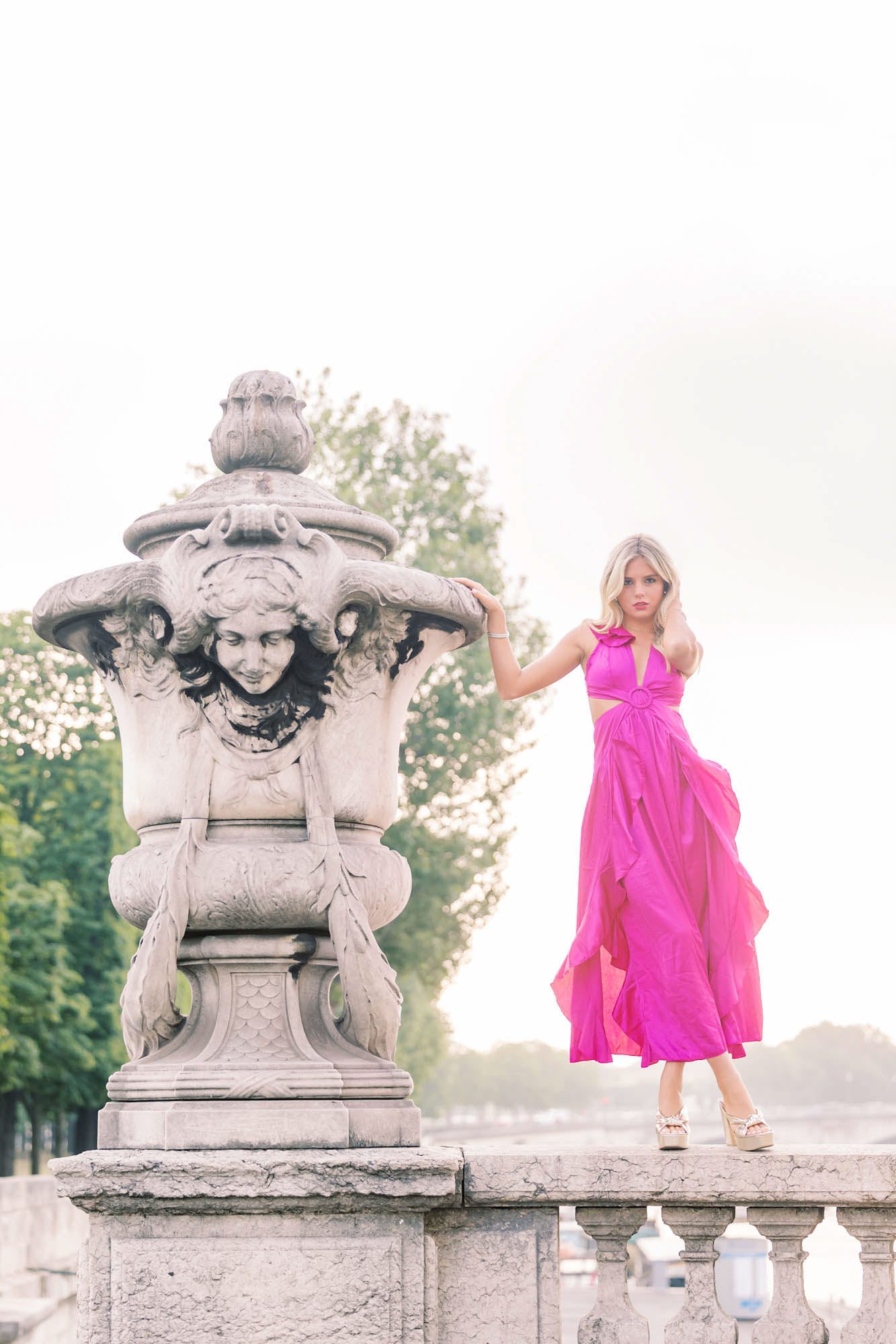 Modern senior portrait of a girl leaning on a stone sculpture at Pont Alexandre III in Paris