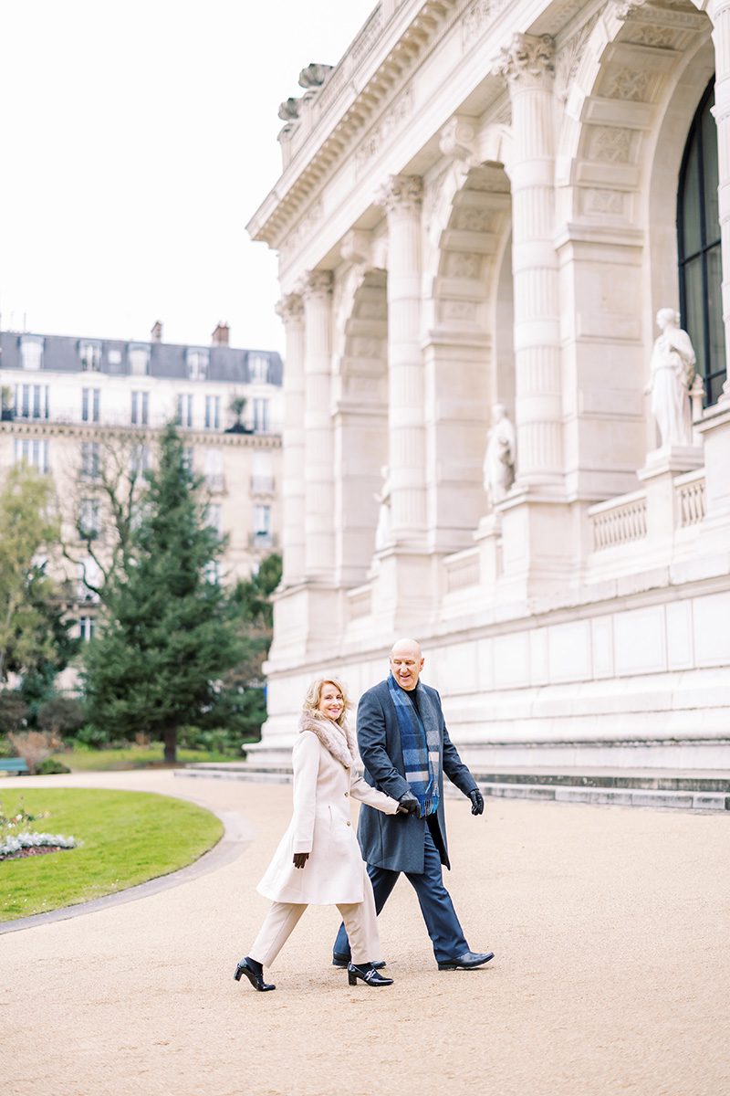 paris photographer review photo of a couple walking at Palais Galleria garden in winter attire.